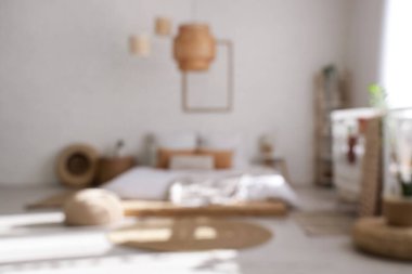 Bulanık ışıklı oda, yatak, bebek beşiği ve bitkiler.