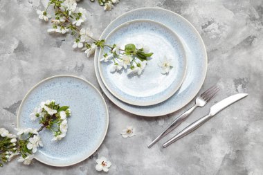 Gri arkaplanda çiçek açan dalları olan güzel masa ayarları