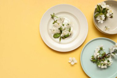 Sarı arka planda çiçek açan dalları olan farklı temiz tabakalar.