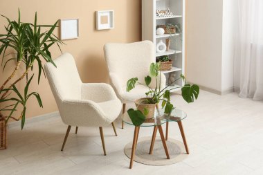 Beyaz koltukları, kahve masası ve sepetleri olan şık bir oturma odası.