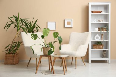 Beyaz koltukları, kahve masası ve sepetleri olan şık bir oturma odası.