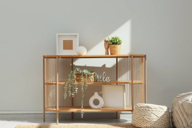 Gri duvarın yanındaki sepetlerde ev bitkileri olan ahşap masa.