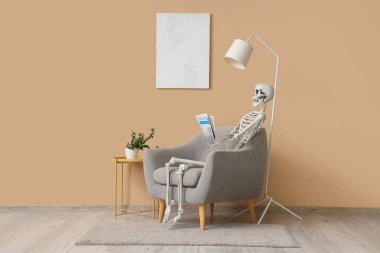 İskelet ve gazete oturma odasındaki bej duvarın yanındaki koltukta oturuyor.