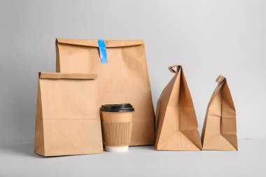 Arka planda kahve fincanı olan kağıt poşetler. Yemek dağıtım servisi.