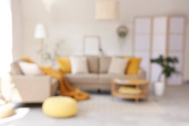 Rahat gri kanepesi, sehpası ve çiçekleri olan şık bir oturma odası.