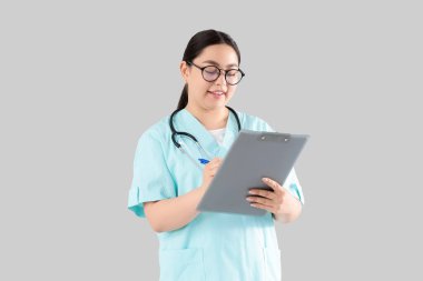 Kadın doktor arka planda panoya yazı yazıyor.