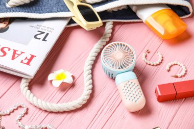 Yaz aksesuarları ve pembe ahşap arka planda mini yelpaze.