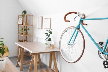 Oturma odasının içinde bisiklet, masa ve raf ünitesi