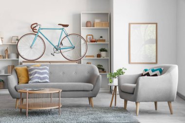 Oturma odasının içinde bisiklet, kanepe ve koltuk var.