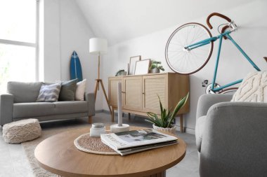 Bisiklet, kanepe ve koltuklu aydınlık oturma odasının içinde.