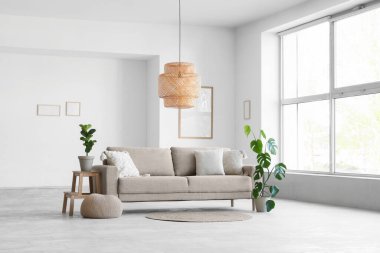 Oturma odasının içinde kanepe ve çiçek var.