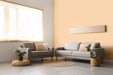 Pencereye yakın kanepeleri olan oturma odasının içinde.