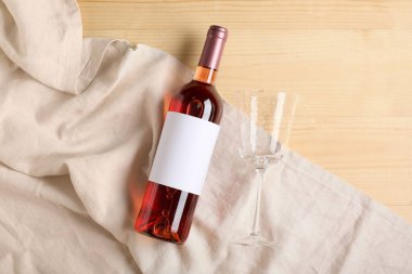 Boş etiketli bir şişe şarap ve ahşap zemin üzerinde cam.