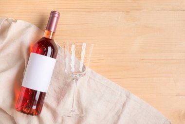 Boş etiketli bir şişe şarap ve ahşap zemin üzerinde cam.