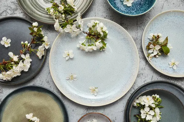 Gri arkaplanda çiçek açan dalları olan farklı temiz tabakalar.