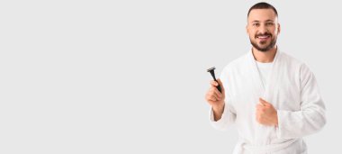 Bornozlu genç adam beyaz arka planda jilet tutuyor ve mesaj için yeri var.