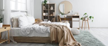 Yatak odasının içinde yatak odası, raf bölümü ve tuvalet masası var.