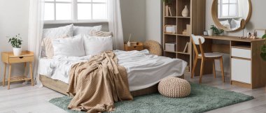 Yatak odasının içinde yatak odası, raf bölümü ve tuvalet masası var.