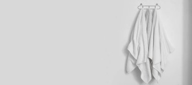 Banyodaki ışık duvarında asılı temiz yumuşak havlular. Tasarım için pankart