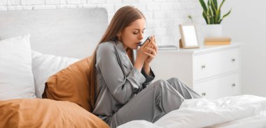 Yatağında astım spreyi olan hasta genç bir kadın.