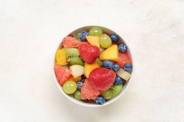 Arka planda taze meyve salatası.