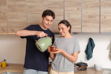 Mutfakta çay içen mutlu genç çift.