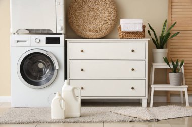 Çamaşır makinesi, deterjan ve klozeti olan bir çamaşırhane.