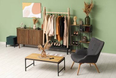 Kadın giysileri, aksesuarları ve rahat koltuğu olan şık bir soyunma odası.