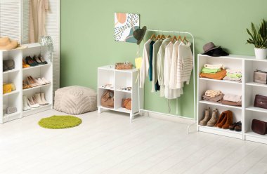 Kadın kıyafetleri, ayakkabıları ve aksesuarları olan şık bir soyunma odası.