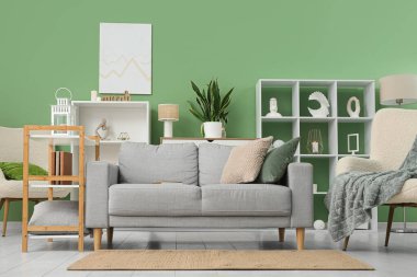 Oturma odasının içinde rahat bir kanepe, koltuk ve raf var.