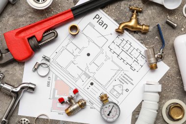 Gri grunge arka planında ev planı olan tesisatçı eşyaları.