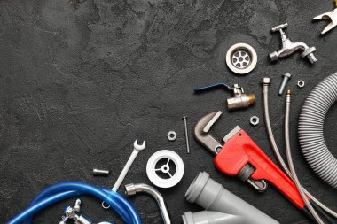 Siyah grunge arka planında tesisatçı eşyaları seti