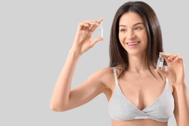 Hafif arka planda ampulleri olan güzel genç bir kadın.