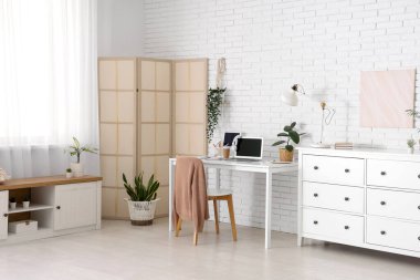 Çalışma alanı, katlama ekranı ve bitkileri olan ofis içi