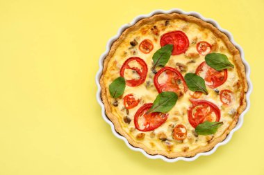 Sarı arka planda ıspanak yapraklı lezzetli domates tartı.