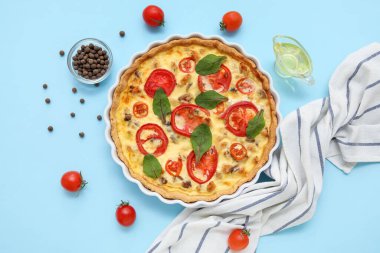 Ispanak yapraklı lezzetli domates tartı ve mavi arka planda biber.