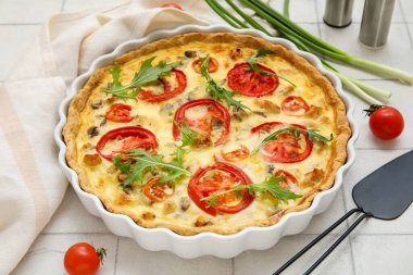 Arugula yapraklı lezzetli domates turtası ve beyaz fayanslı yeşil soğan. Yakın plan.