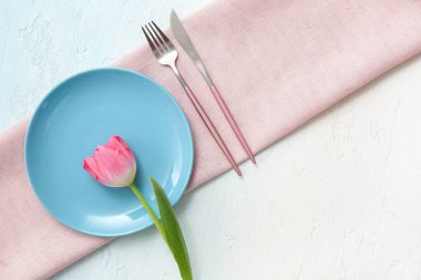 Açık mavi arkaplanda pembe lale çiçekli güzel bir masa.