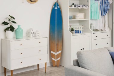 Sörf tahtası ve dolabı olan bir oturma odası.