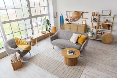 Sörf tahtası, kanepesi ve koltuğu olan bir oturma odası.