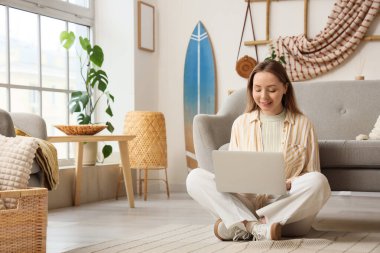 Evde sörf tahtası olan genç bir kadın.