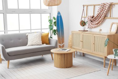 Oturma odasının içinde sörf tahtası, kanepe ve merdiven var.