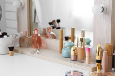 Tuvalet masasında çeşitli makyaj ürünleri var.