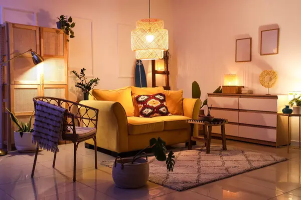 Şık oturma odasının içinde sarı kanepe, parlak lambalar ve akşamları sörf tahtası.
