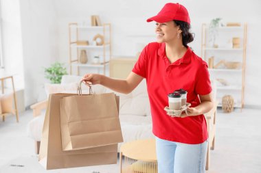 Odasında kese kâğıdı ve kahve fincanı olan Afro-Amerikan kadın kurye. Yemek dağıtım servisi.