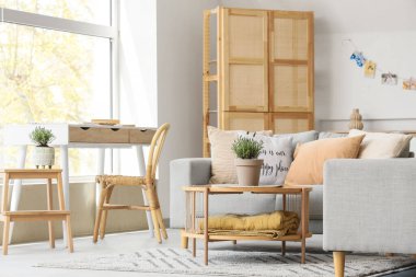 Gri kanepe ve sehpanın üzerinde lavanta çiçekleri olan şık bir oturma odası.