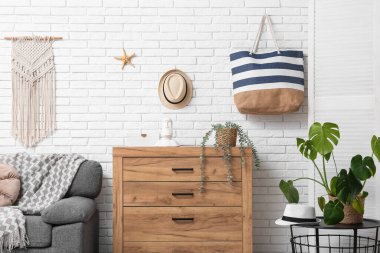 Gri koltuklu, ahşap kostümlü ve yaz dekorlu şık bir oturma odası.