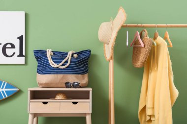 Güneş gözlüklü masa, el çantası ve elbise askısı şık bir odada, yakın plan.