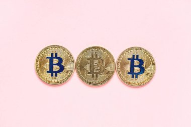 Pembe arka planda altın bitcoinler