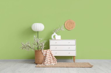 Çiçek açan dalları, klozeti ve lambası olan oturma odasının içinde.